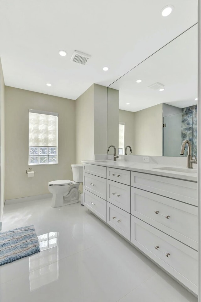 bathroom with toilet, recessed lighting, visible vents, and a sink