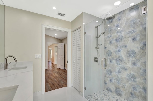 full bathroom featuring a shower stall, double vanity, visible vents, and a sink