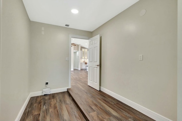 unfurnished room with baseboards and wood finished floors