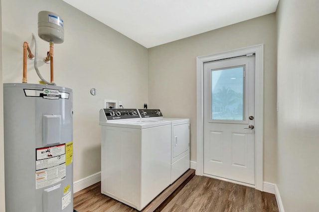 laundry room featuring baseboards, water heater, laundry area, light wood-style flooring, and separate washer and dryer