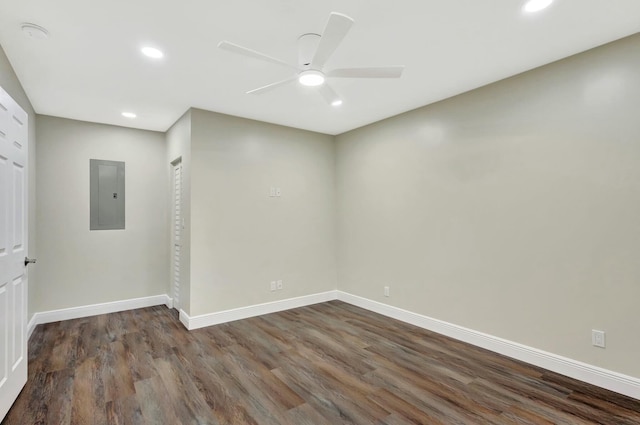 spare room with electric panel, dark wood-style floors, recessed lighting, baseboards, and ceiling fan