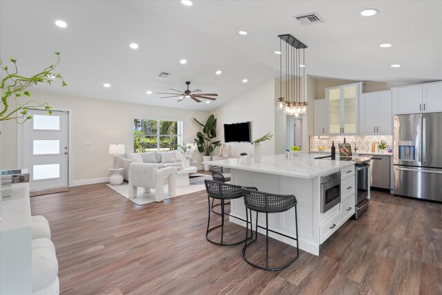 17393 84th Ct N, Loxahatchee, FL 33470 - kitchen featuring stainless steel appliances, white cabinets, a kitchen island with sink, a breakfast bar, and open floor plan