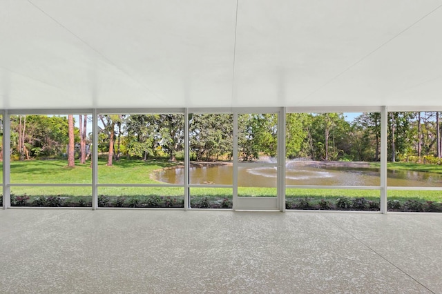 unfurnished sunroom featuring a water view