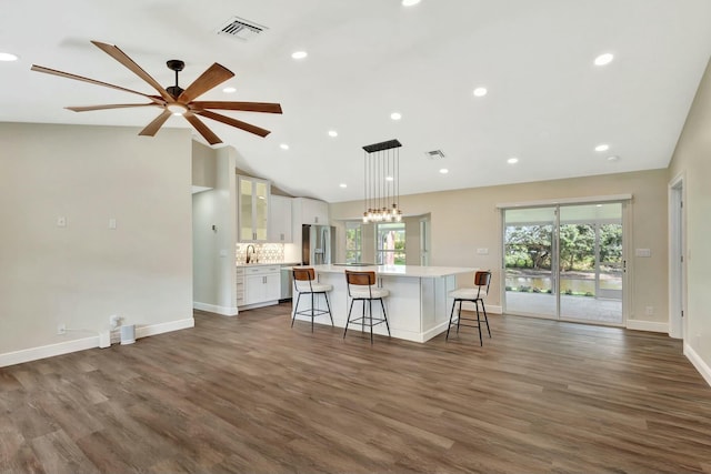 kitchen with visible vents, a breakfast bar, light countertops, stainless steel appliances, and white cabinetry