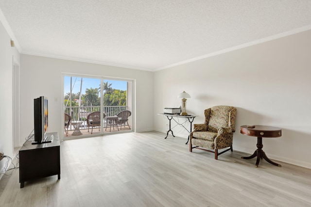 living area with crown molding, light wood-type flooring, and a textured ceiling