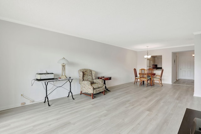 sitting room featuring crown molding, a notable chandelier, and light wood-type flooring