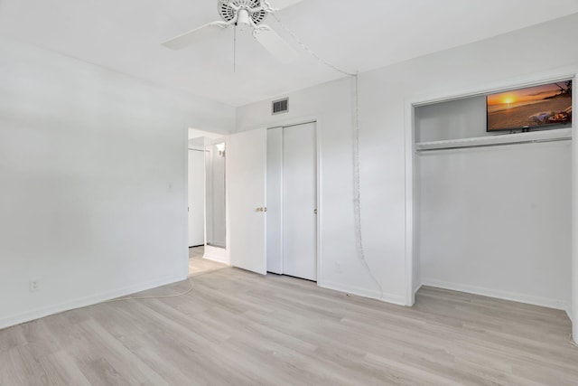 unfurnished bedroom with light wood-type flooring, visible vents, two closets, baseboards, and ceiling fan