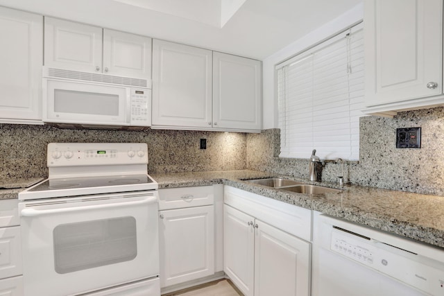 kitchen with tasteful backsplash, white appliances, and a sink