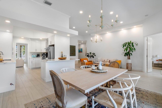 dining room featuring visible vents, light wood finished floors, an inviting chandelier, recessed lighting, and crown molding