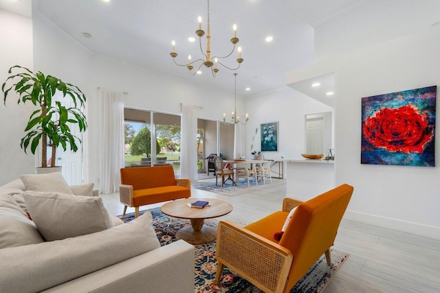 living area with an inviting chandelier, crown molding, baseboards, and light wood-type flooring