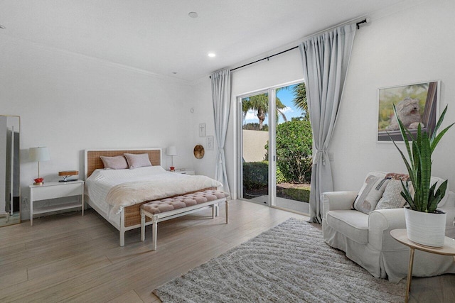 bedroom with recessed lighting, light wood-style flooring, ornamental molding, and access to outside