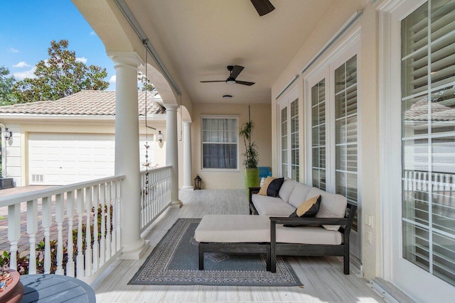 deck with an outdoor living space, ceiling fan, and an attached garage