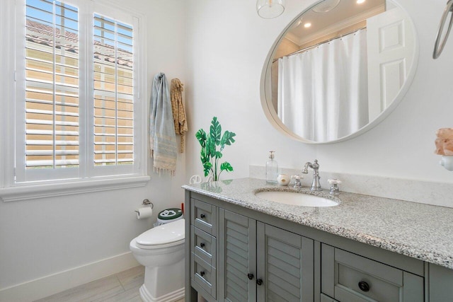 full bath with vanity, toilet, and baseboards