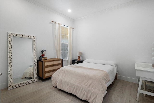 bedroom featuring wood finished floors, baseboards, and ornamental molding