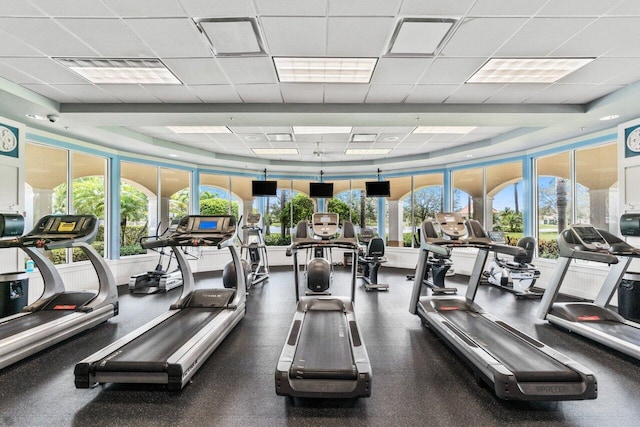 exercise room featuring a drop ceiling, visible vents, and plenty of natural light