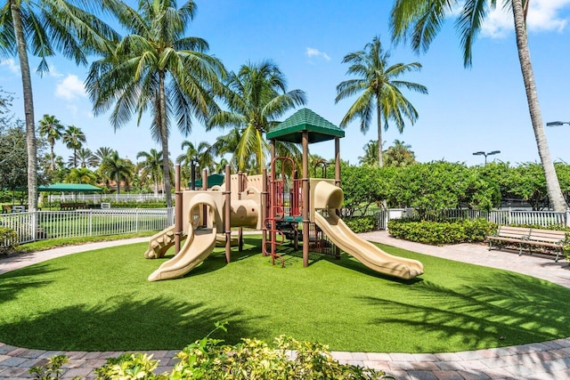 community play area featuring a lawn and fence