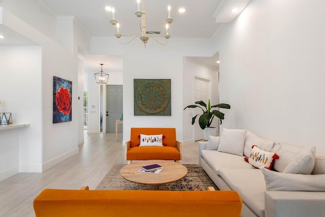 living area with light wood finished floors, an inviting chandelier, baseboards, and ornamental molding