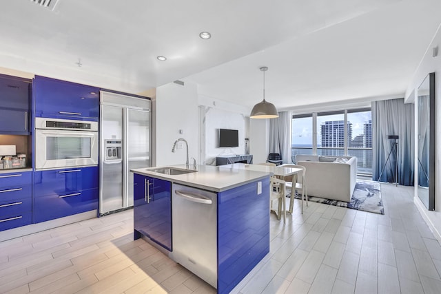 kitchen featuring modern cabinets, a sink, stainless steel appliances, and open floor plan