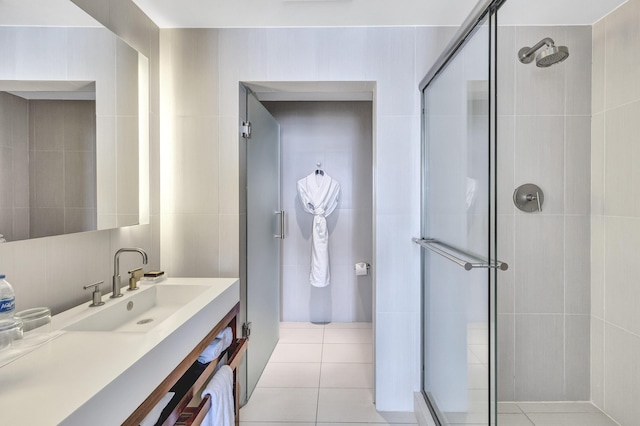 full bathroom featuring a shower stall, tile patterned floors, vanity, and tile walls