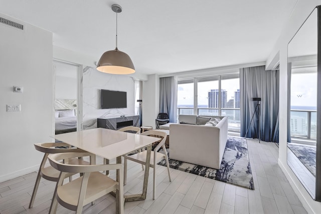 dining area with wood tiled floor, visible vents, and baseboards