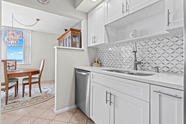 kitchen with decorative backsplash, stainless steel dishwasher, light tile patterned flooring, white cabinets, and a sink