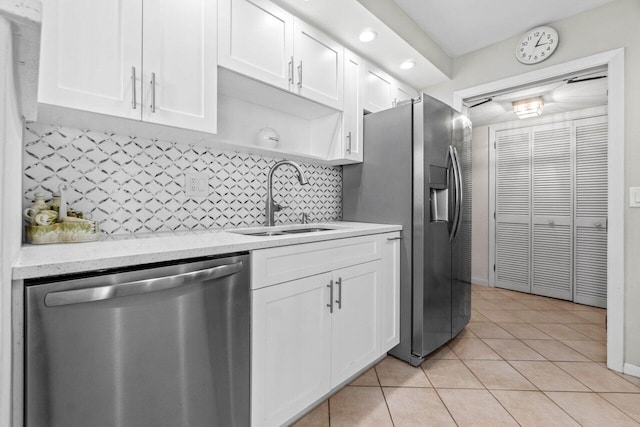 kitchen with white cabinetry, light tile patterned flooring, appliances with stainless steel finishes, and a sink