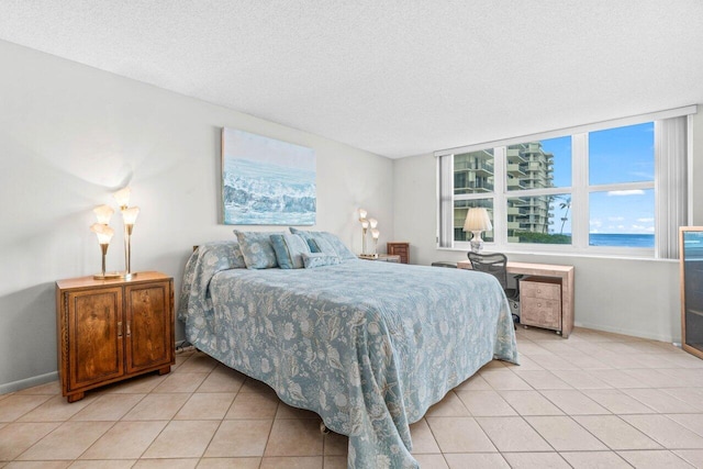 bedroom with light tile patterned floors, baseboards, and a textured ceiling