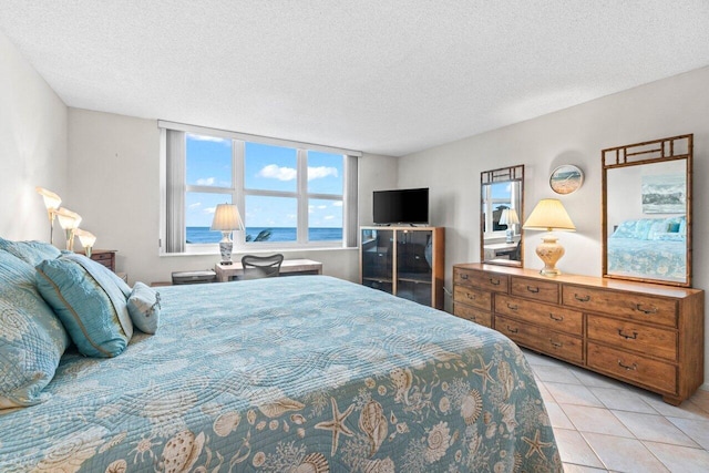 bedroom with light tile patterned floors and a textured ceiling