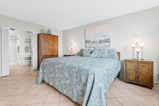 bedroom featuring baseboards, a textured ceiling, and light tile patterned flooring