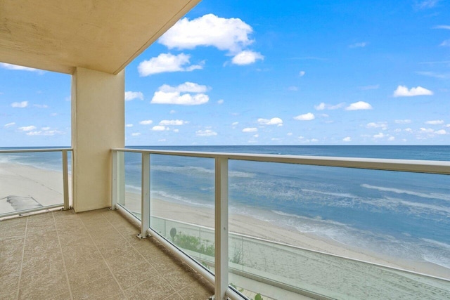 balcony featuring a beach view and a water view