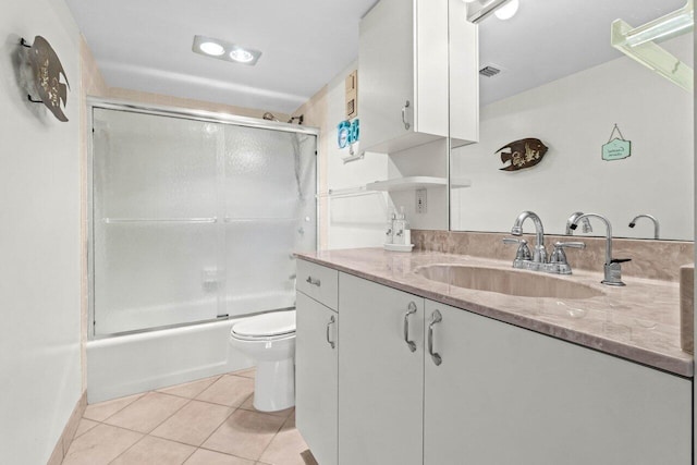 bathroom with visible vents, toilet, combined bath / shower with glass door, tile patterned flooring, and vanity