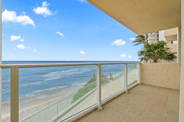 balcony featuring a beach view and a water view