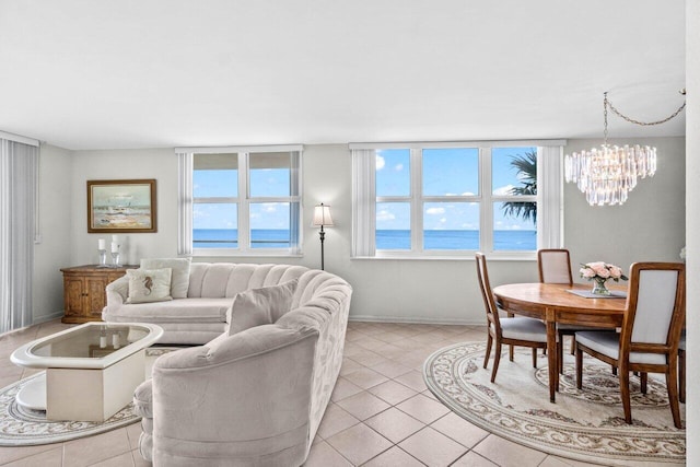 living area with a wealth of natural light, light tile patterned floors, baseboards, and an inviting chandelier