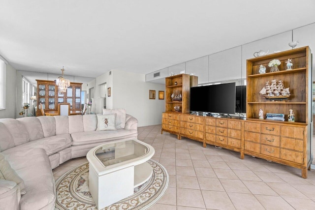 living room with light tile patterned floors, visible vents, and a chandelier