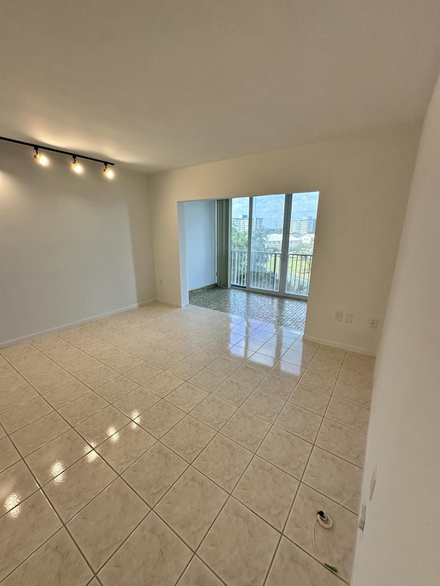 3850 Washington St Unit 510, Hollywood, FL 33021 - empty room with rail lighting, light tile patterned floors, and baseboards
