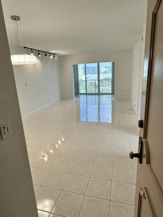 3850 Washington St Unit 510, Hollywood, FL 33021 - empty room with rail lighting, light tile patterned floors, and baseboards