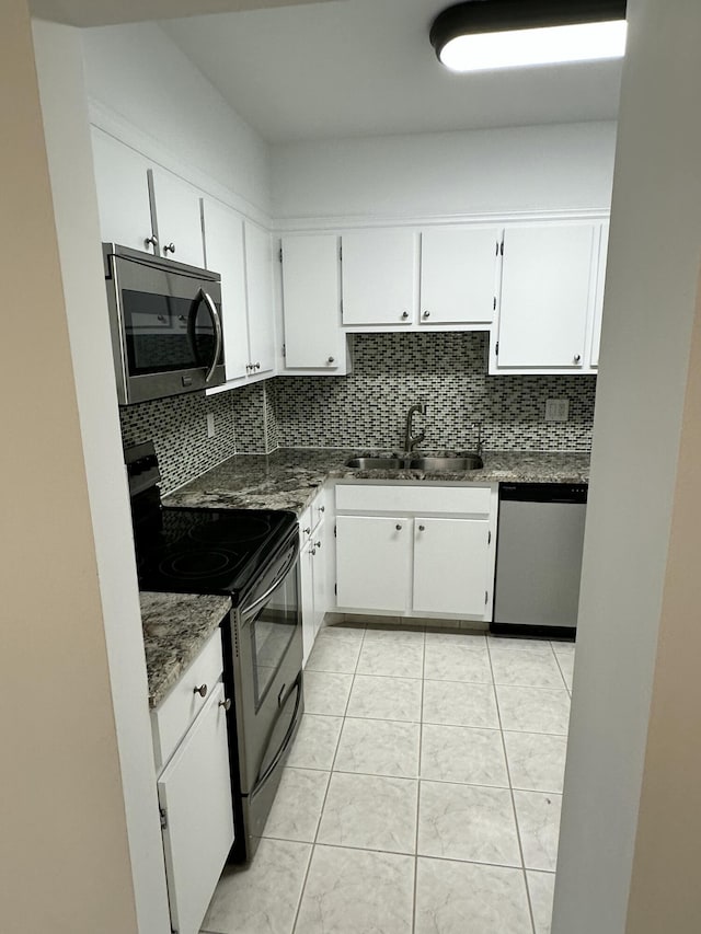 3850 Washington St Unit 510, Hollywood, FL 33021 - kitchen with stainless steel appliances, white cabinetry, a sink, and decorative backsplash