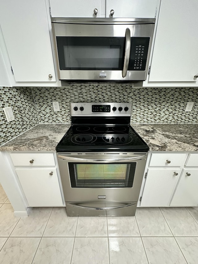 3850 Washington St Unit 510, Hollywood, FL 33021 - kitchen featuring decorative backsplash, white cabinetry, marble finish floor, and stainless steel appliances