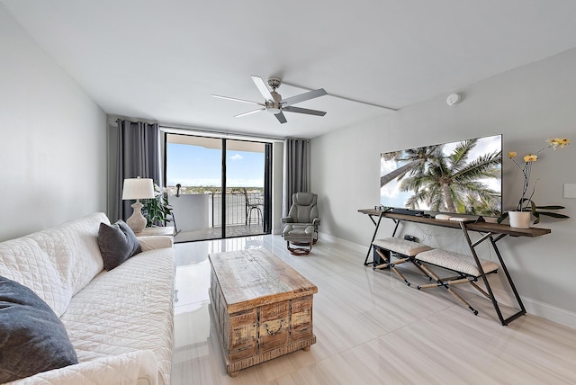 living room featuring a wall of windows, a ceiling fan, and baseboards