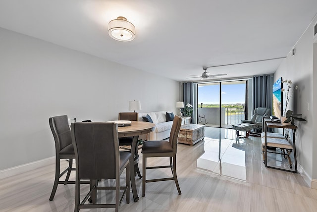 dining area with baseboards, a ceiling fan, and floor to ceiling windows