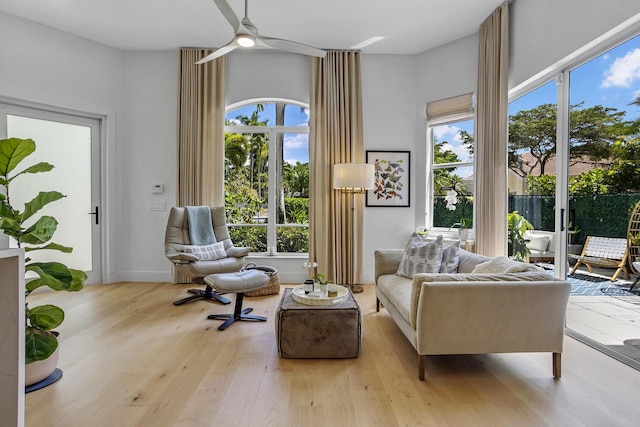 sitting room featuring a wealth of natural light, wood finished floors, and ceiling fan