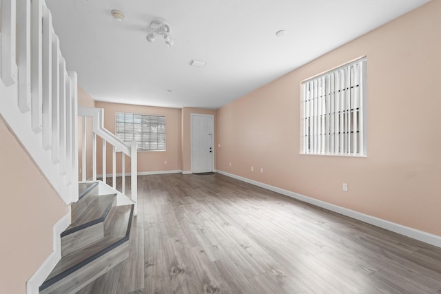 entrance foyer with baseboards, wood finished floors, and stairs