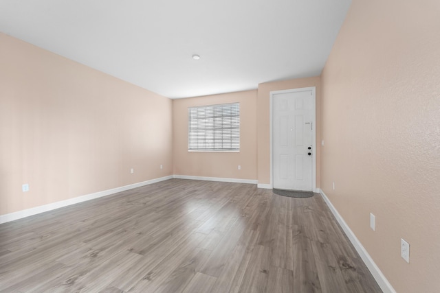 unfurnished room with light wood-style flooring and baseboards