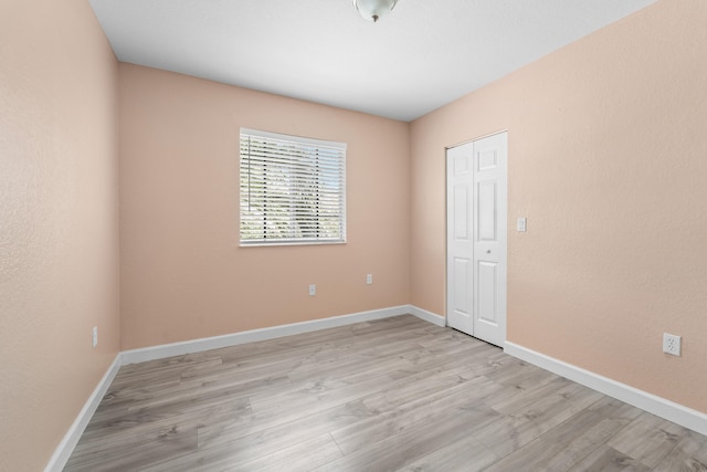 empty room featuring light wood-style floors and baseboards