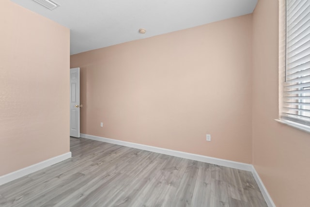 empty room featuring light wood-style flooring, baseboards, and visible vents