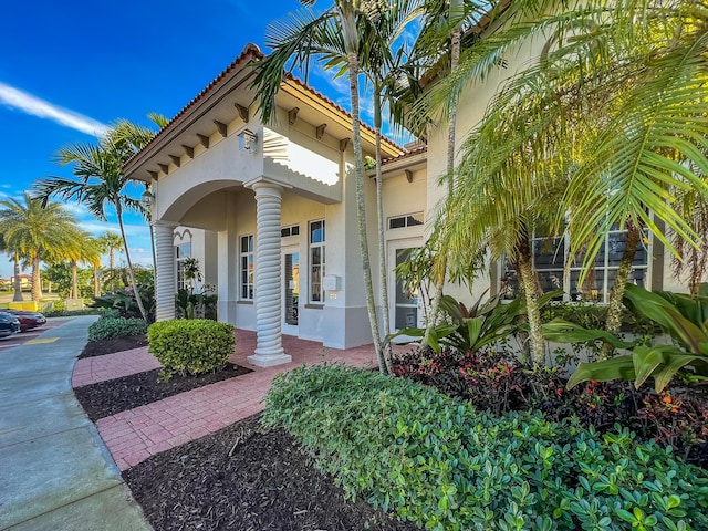 mediterranean / spanish house featuring a tiled roof and stucco siding