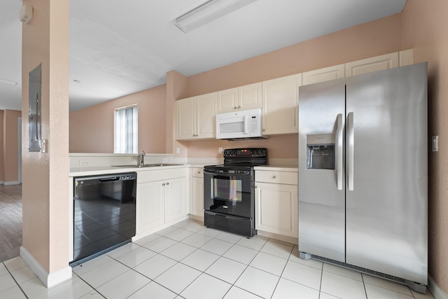 kitchen with light tile patterned floors, a sink, black appliances, white cabinets, and light countertops