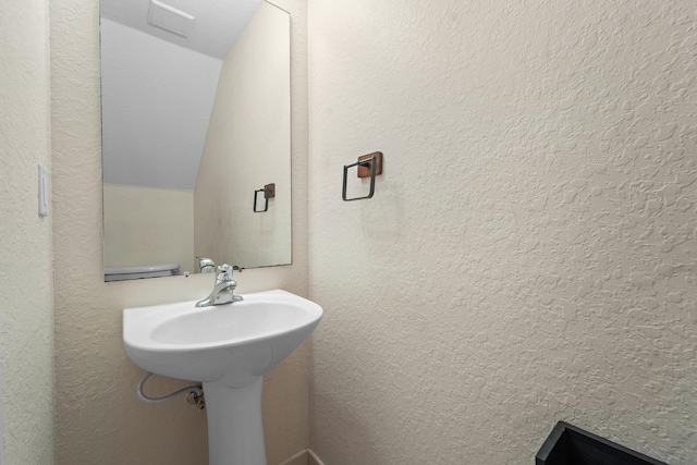 bathroom featuring a textured wall and visible vents