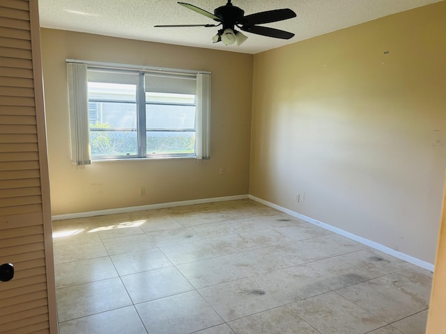 spare room featuring baseboards, a textured ceiling, and ceiling fan