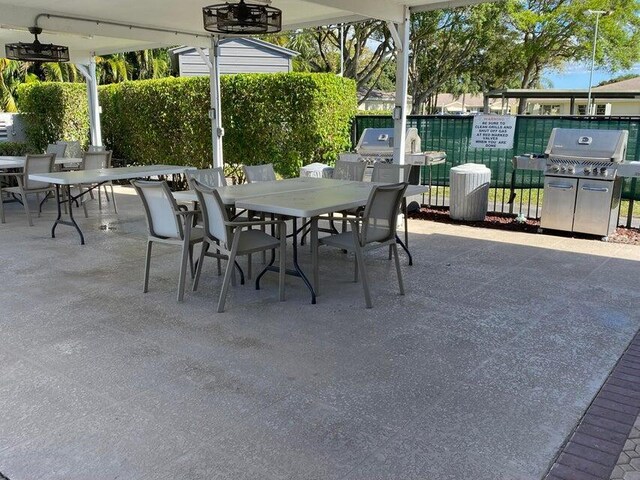 view of patio with outdoor dining space, area for grilling, and fence